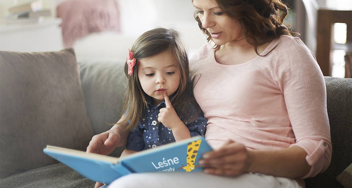 Mama czyta swojej córce personalizowaną książkę z bajkami